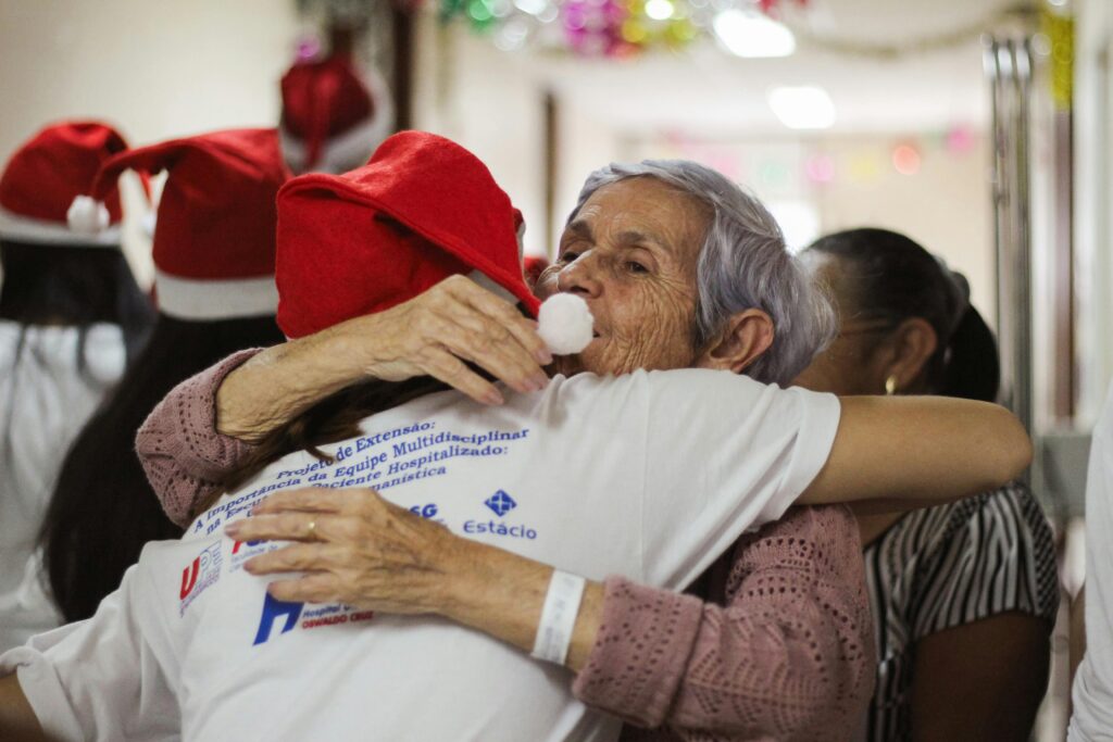 A woman hugs an elderly woman in a hospital